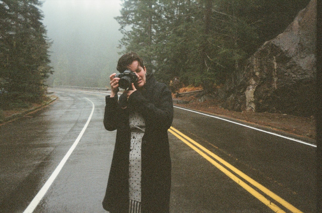woman in black coat standing on road