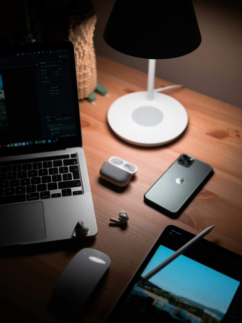 macbook pro beside silver iphone 6 and apple magic mouse on brown wooden table