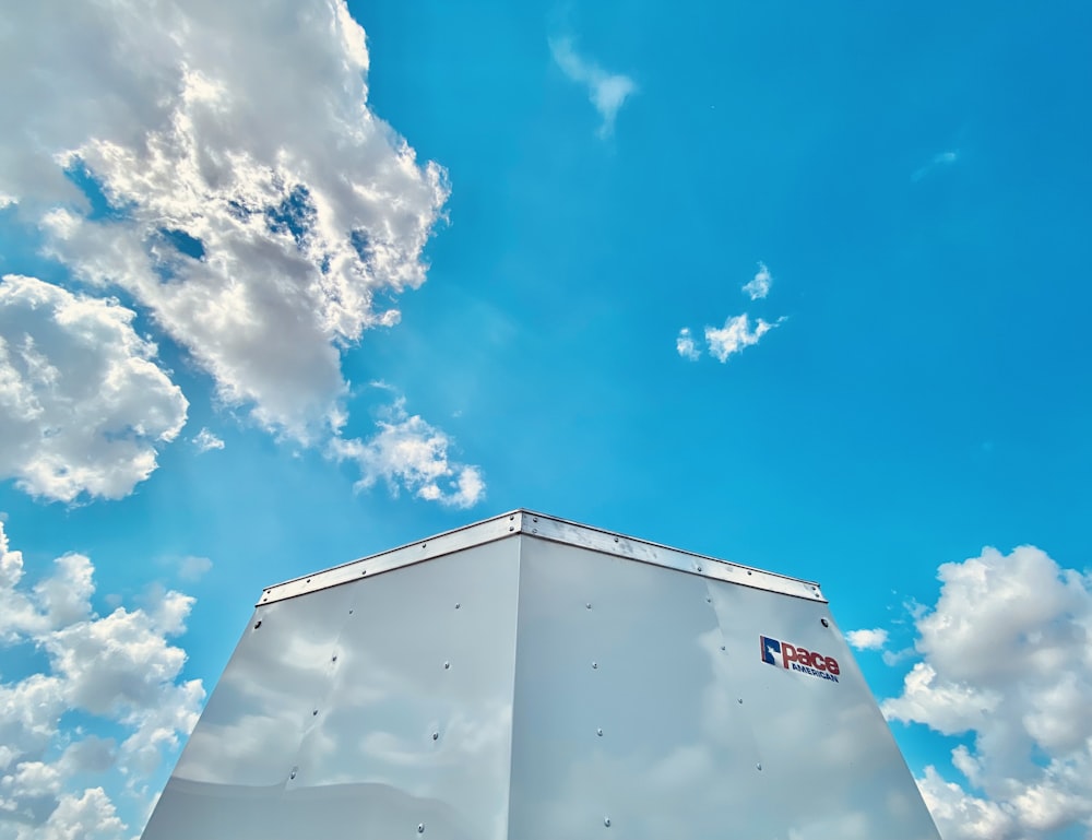 white building under blue sky and white clouds during daytime