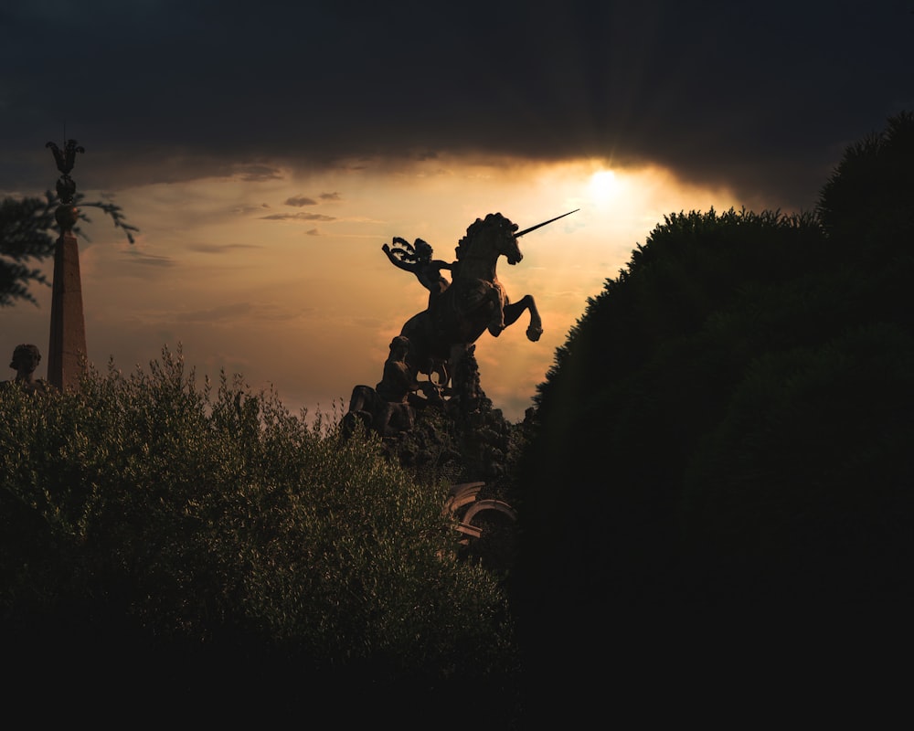 Silueta del hombre sosteniendo el palo durante la puesta del sol