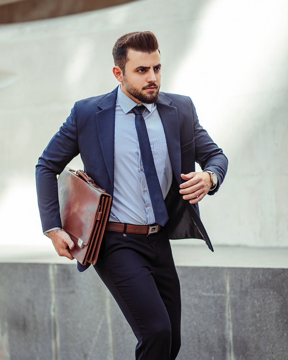 Foto Hombre con chaqueta de traje azul y pantalón negro sosteniendo una  bolsa de cuero marrón – Imagen استان تهران، ایران gratis en Unsplash