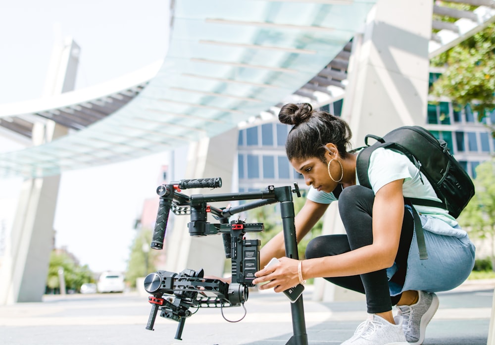 woman in blue tank top holding black camera