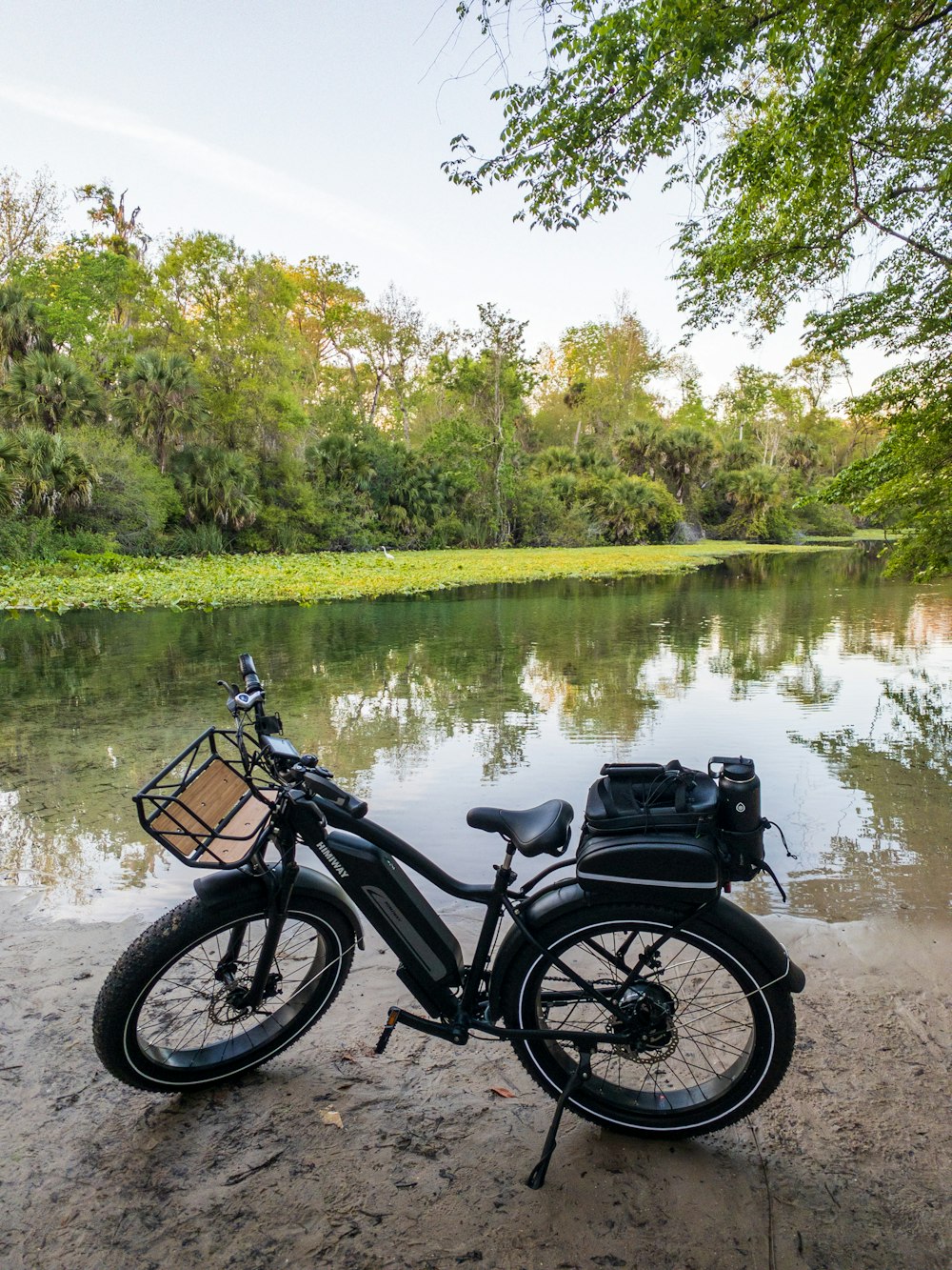 black motorcycle parked beside river during daytime