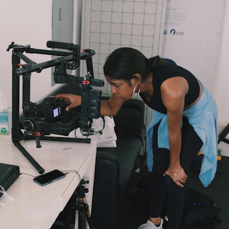 Engineer inspecting a camera module in a modern lab filled with technical equipment.