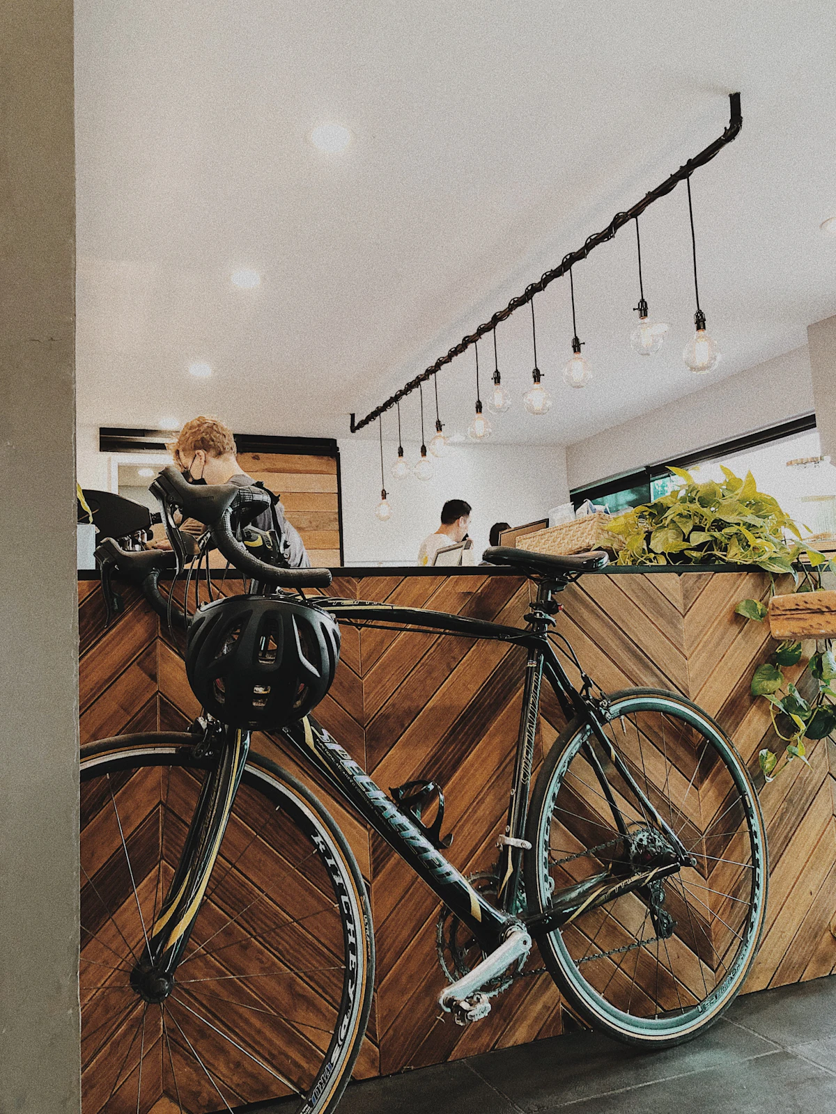 A bicycle with a helmet on the handlebar, parked inside a café