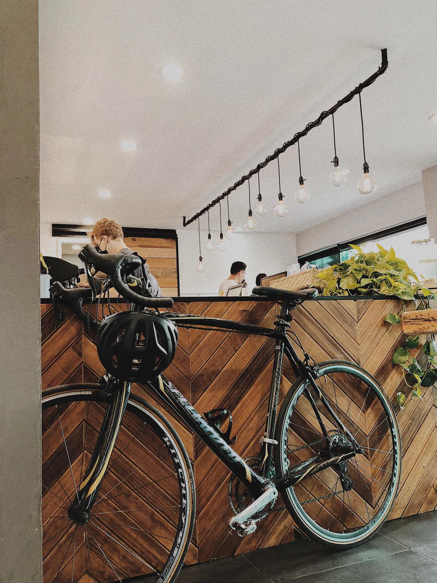 A bicycle with a helmet on the handlebar, parked inside a café
