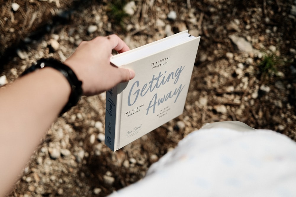 person holding white and blue book