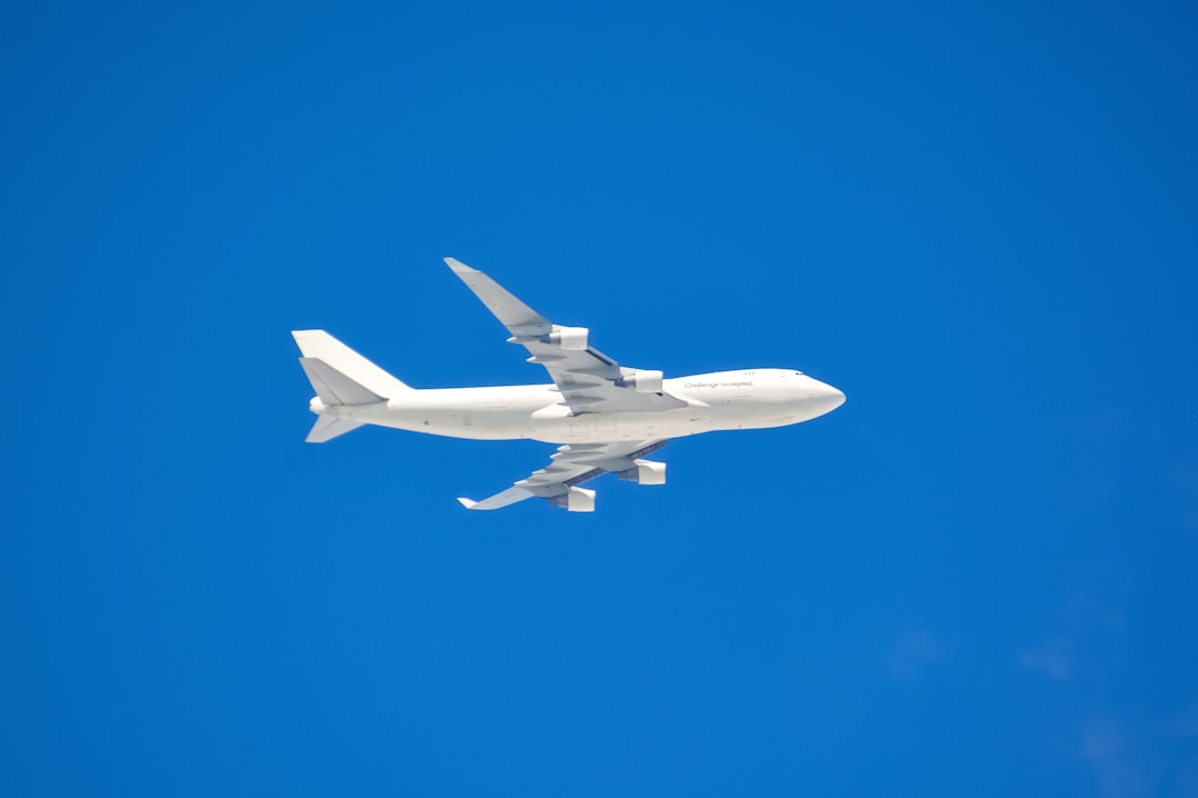 white airplane in mid air during daytime