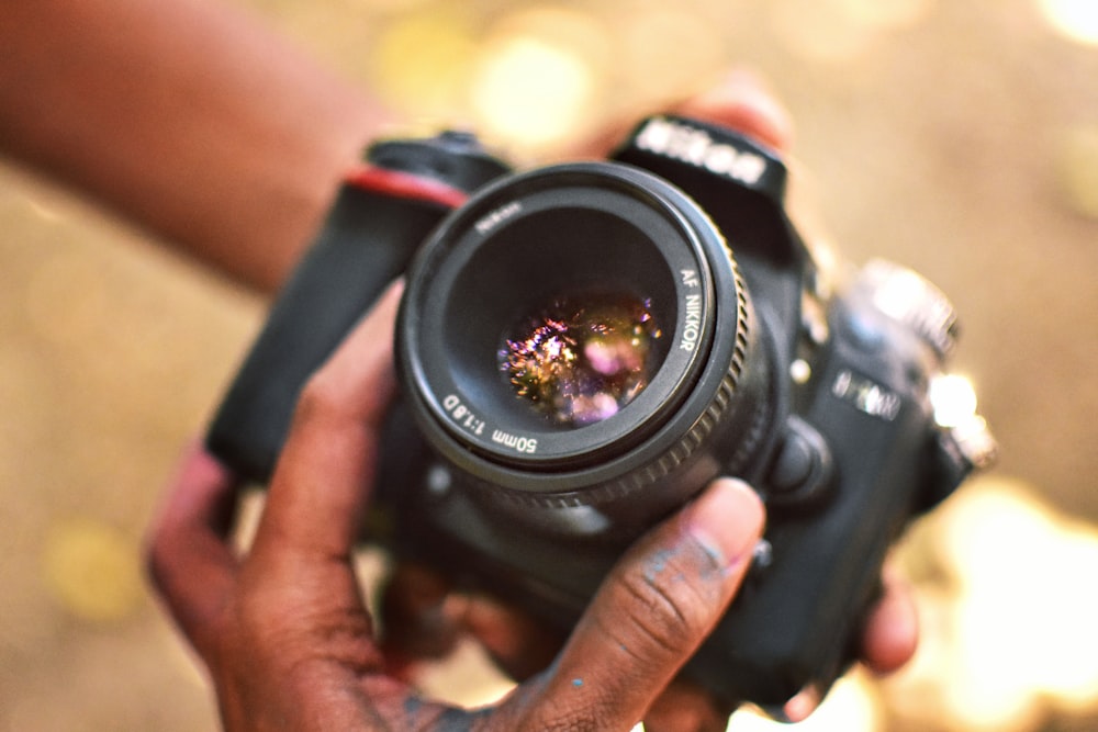 person holding black nikon dslr camera