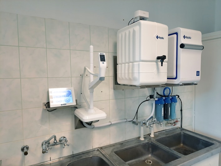 A modern water purifier installed in a cozy kitchen setting.