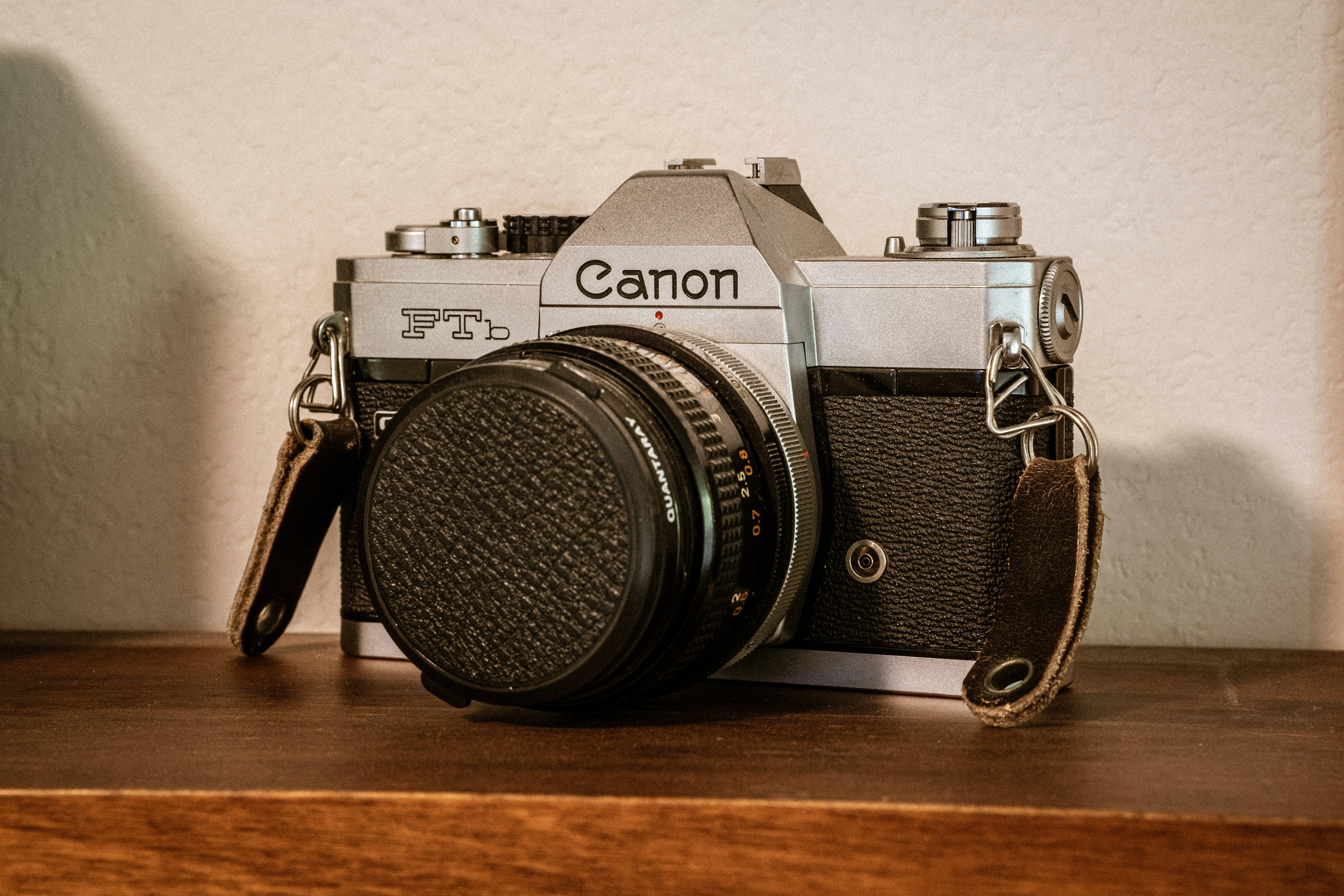 black and silver pentax camera on brown wooden table