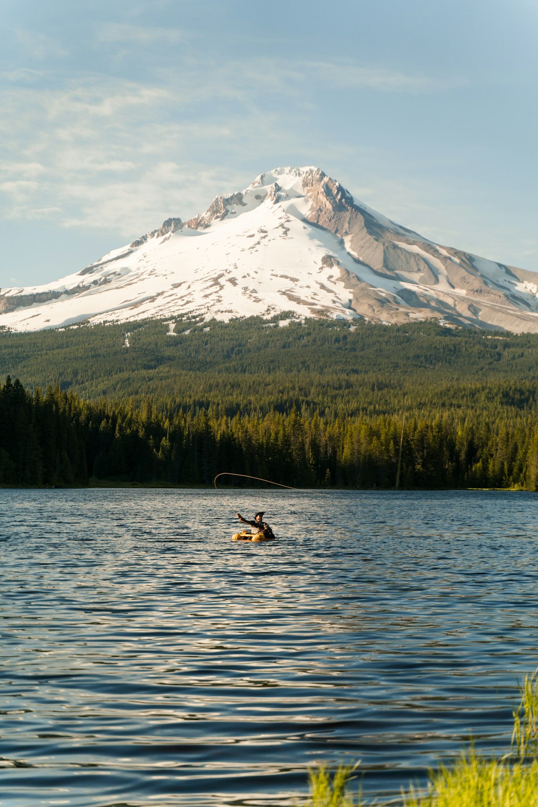 person riding on boat on lake near snow covered mountain during daytime