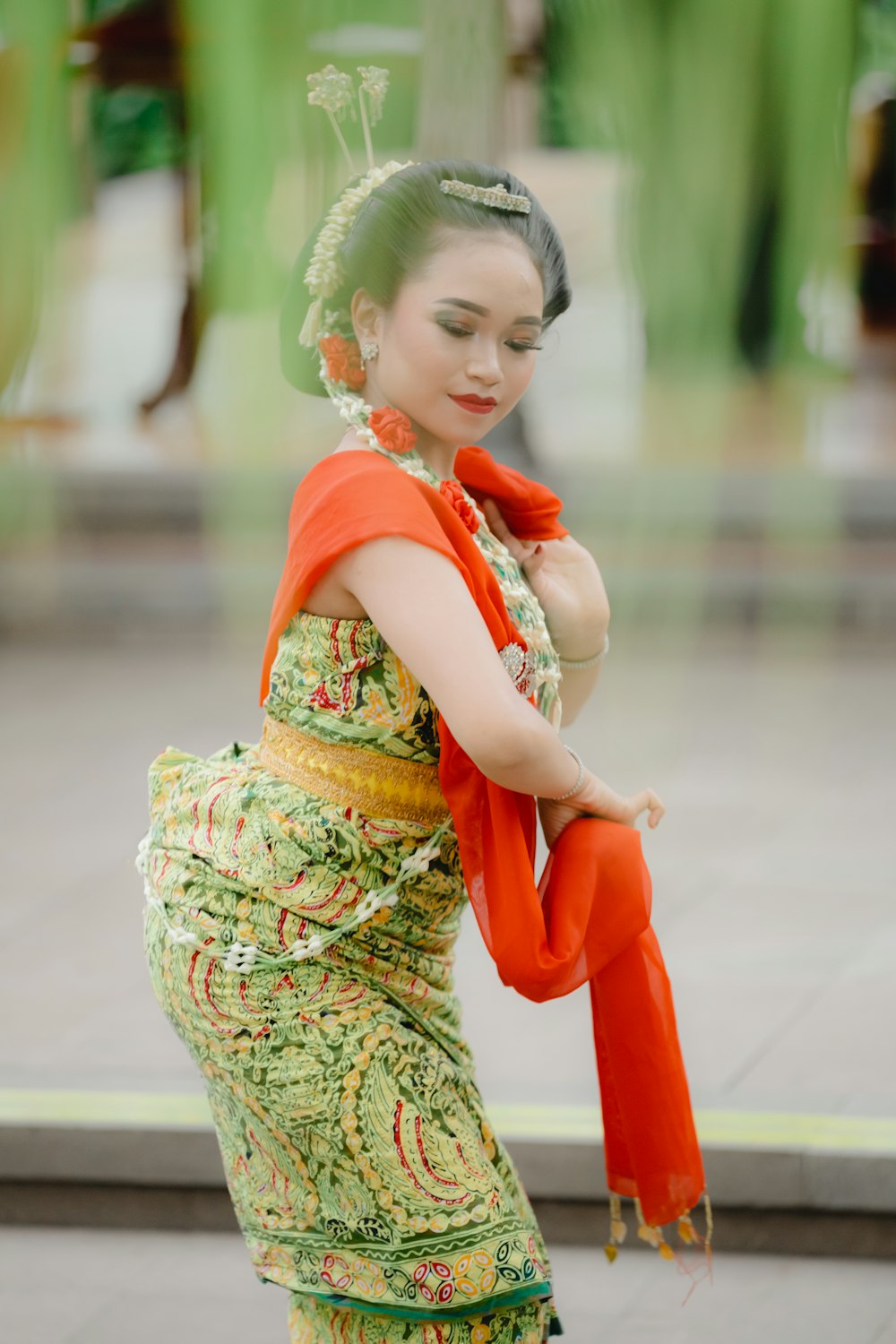 girl in green and yellow dress holding red balloon