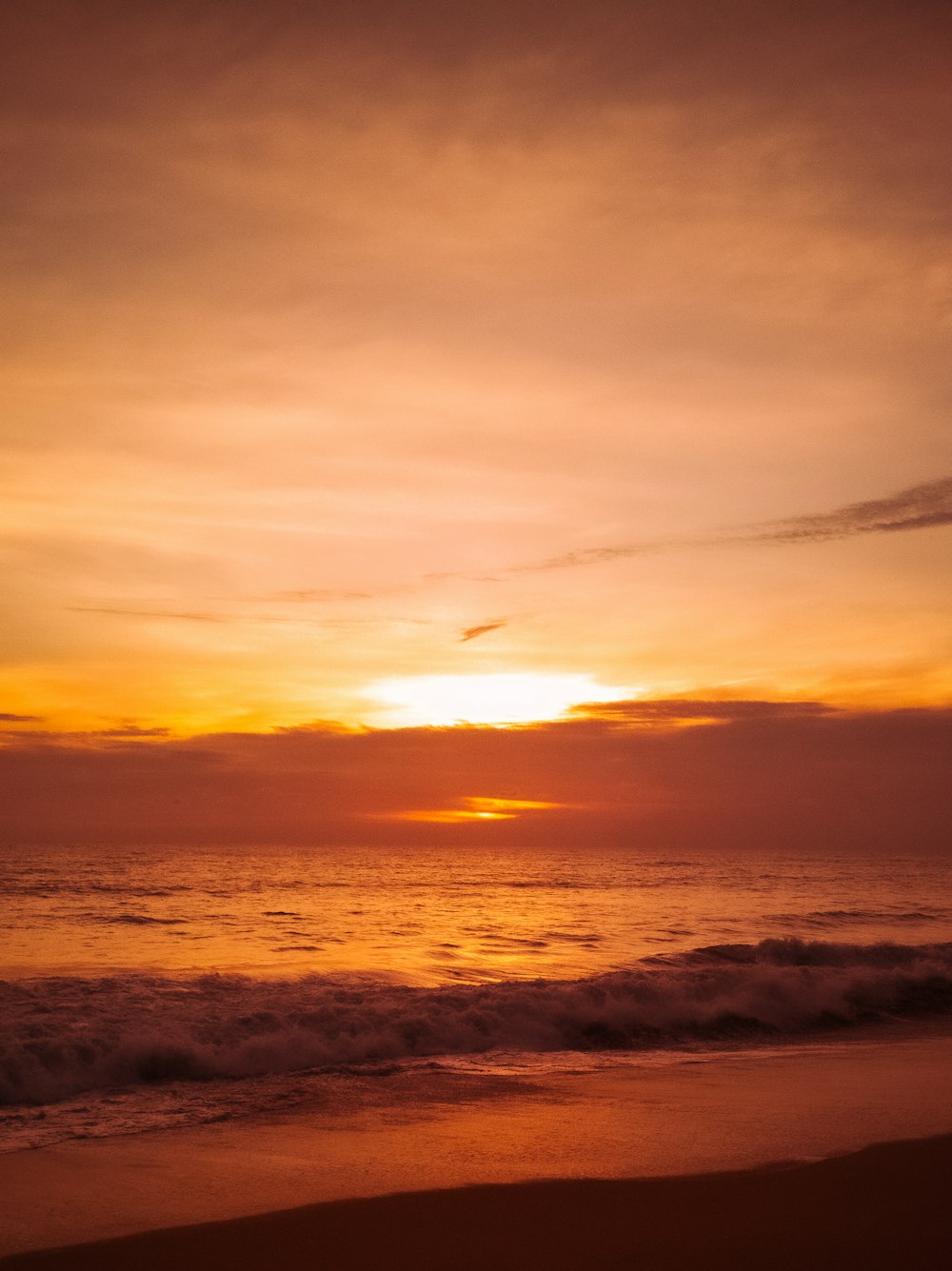 sea waves crashing on shore during sunset