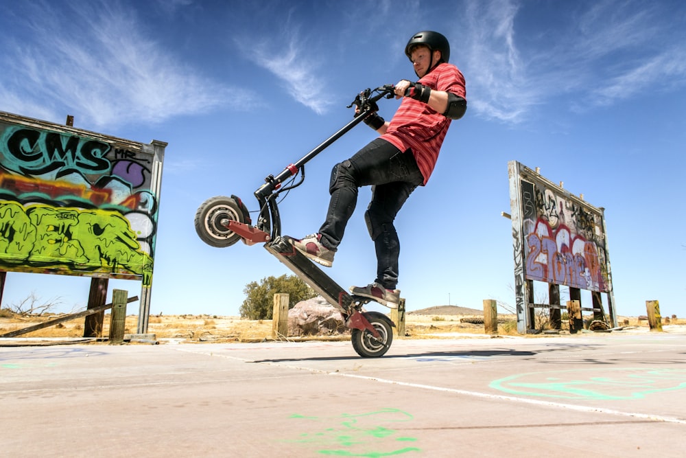 man in red and black jacket riding skateboard during daytime