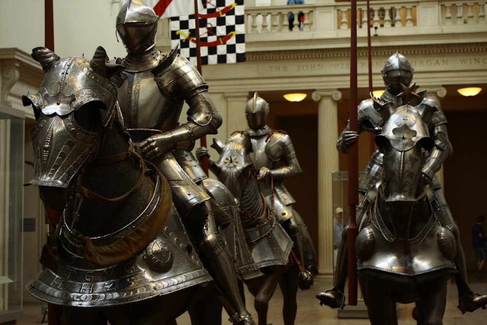 Estatua de 3 hombres en traje dorado y negro