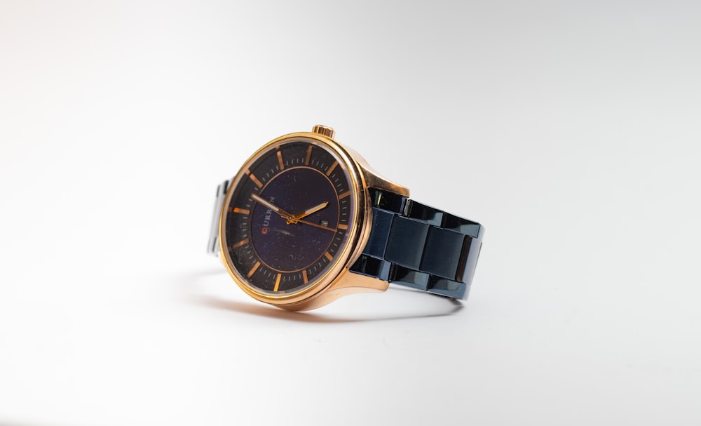 gold and black round analog watch