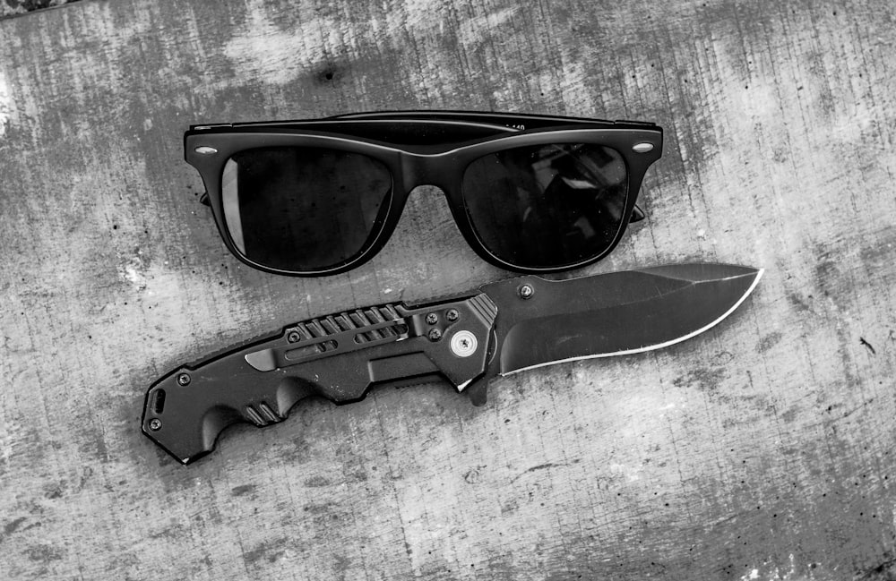 black framed sunglasses on white wooden table