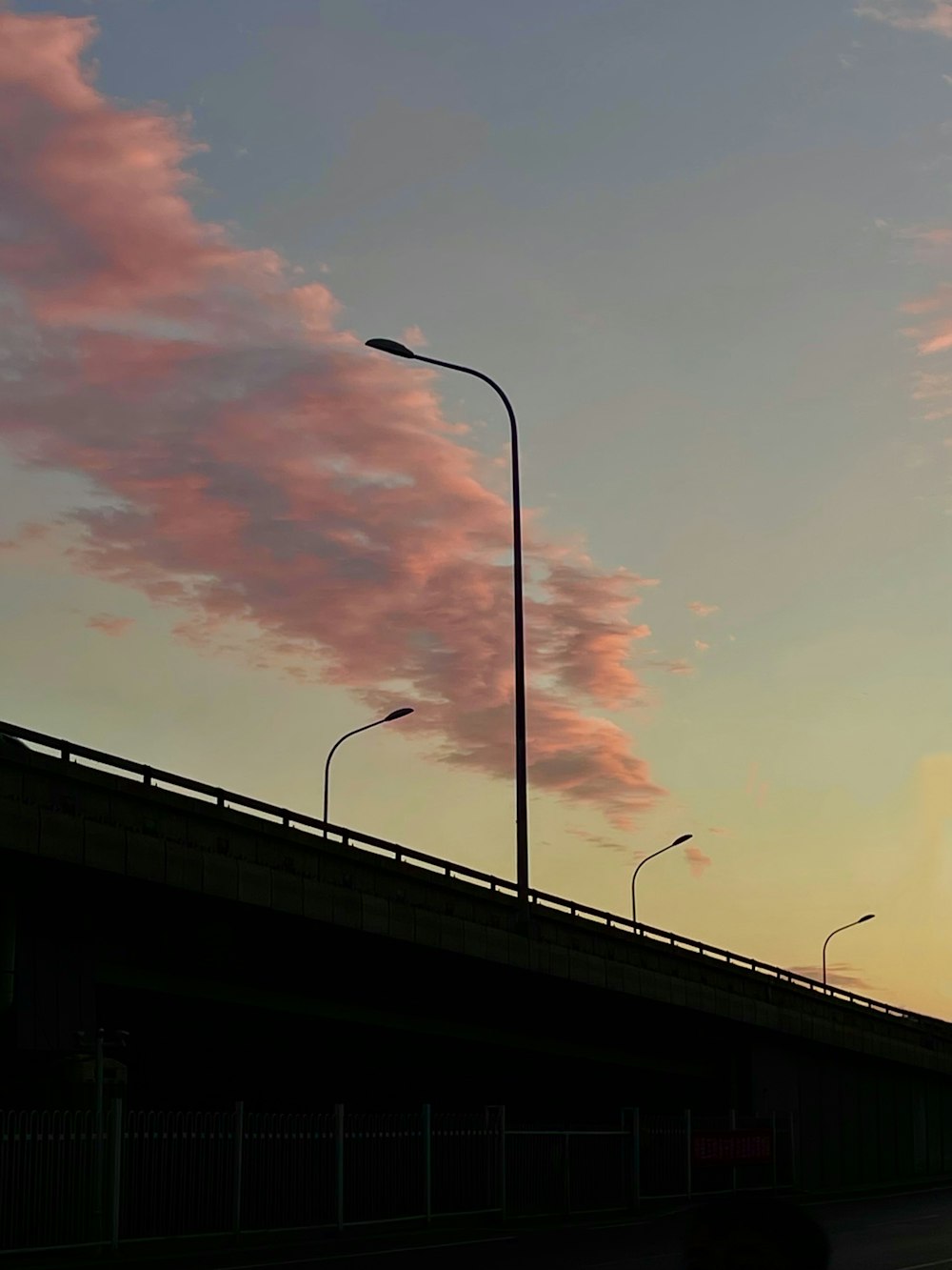 a street light on a bridge with a sky background