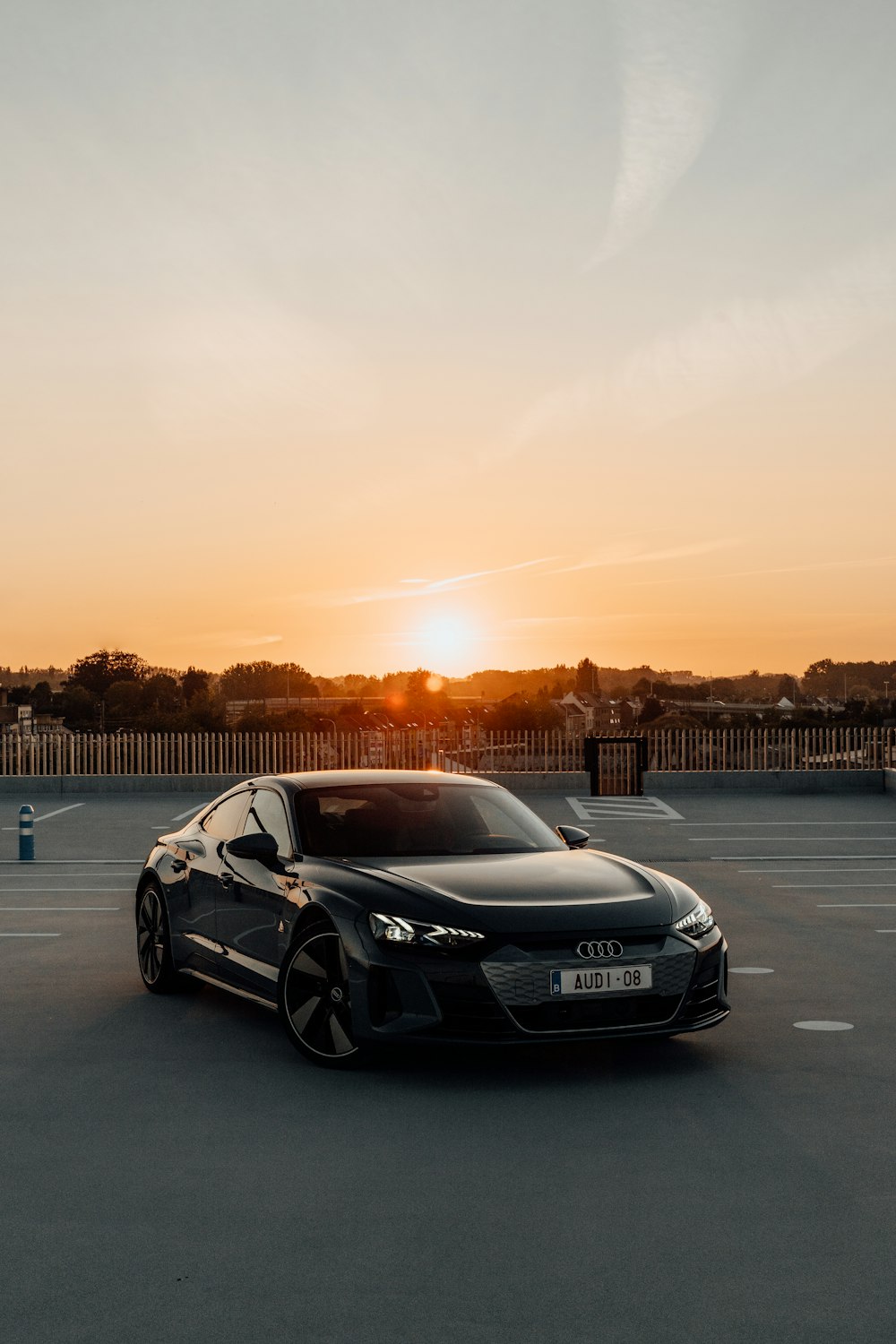 Porsche 911 noire sur la route au coucher du soleil