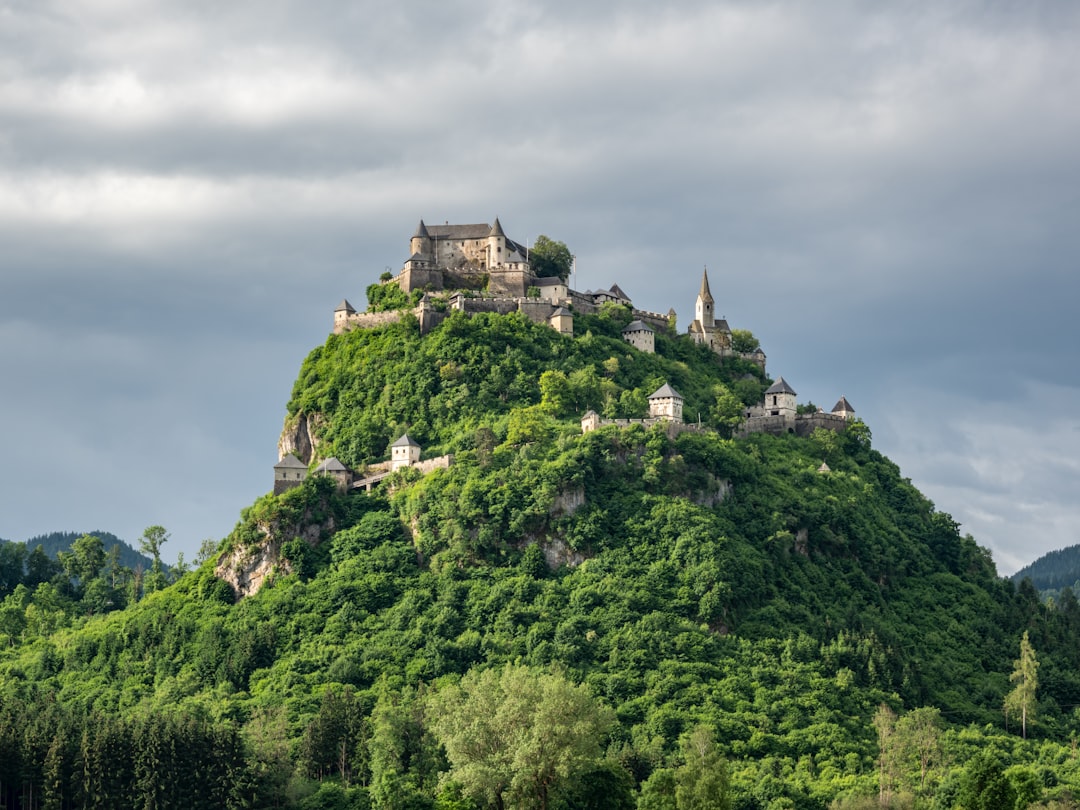 green trees on mountain under cloudy sky during daytime