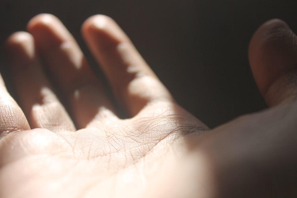 persons left hand on black background