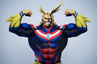A muscular animated character with exaggerated features stands confidently, wearing a colorful costume with blue, red, and white stripes alongside yellow gauntlets. The character's blonde hair is styled in pointed shapes, and they are posed flexing both arms to showcase strength and power.