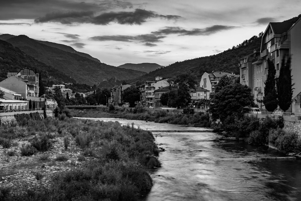 grayscale photo of houses near river