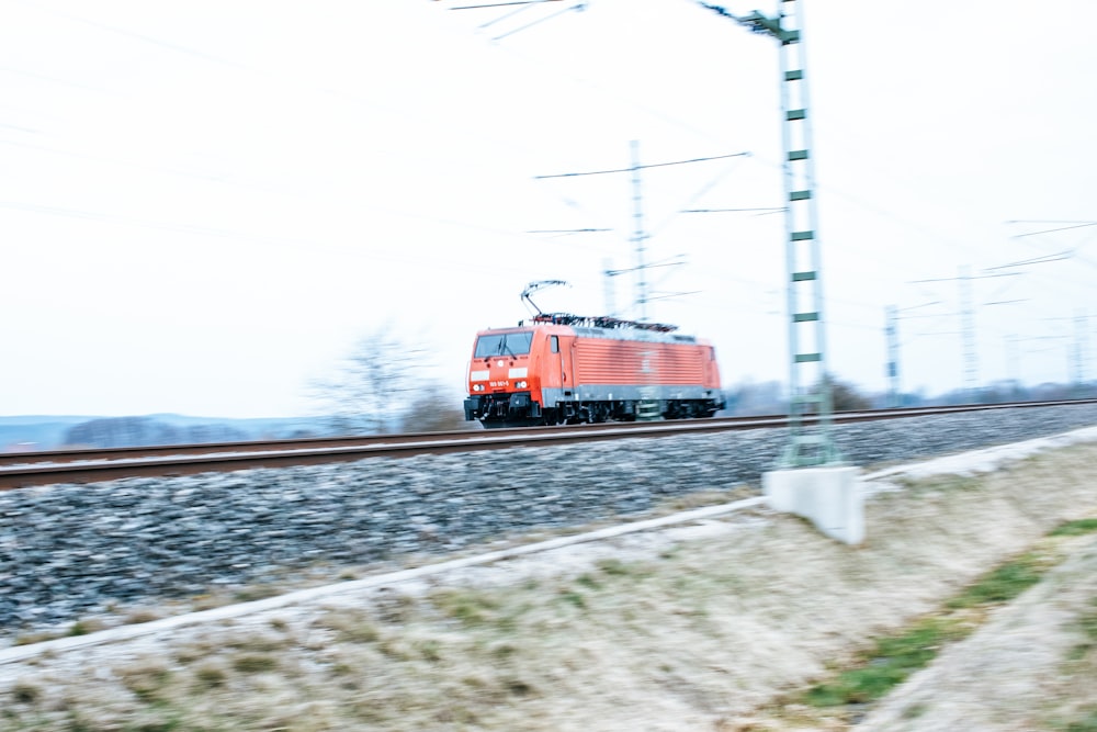 rot-schwarzer Zug tagsüber auf Bahngleisen