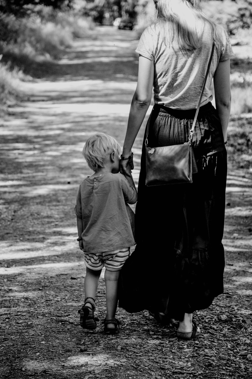 grayscale photo of 2 children walking on beach