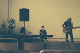 A musician playing an acoustic guitar beside a rustic altar.