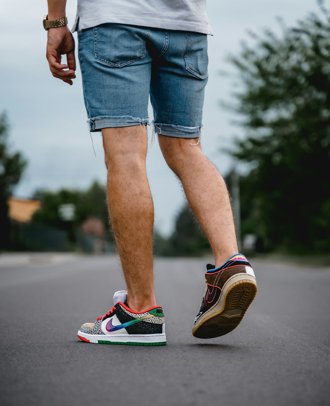 person in blue denim shorts and blue and white nike sneakers