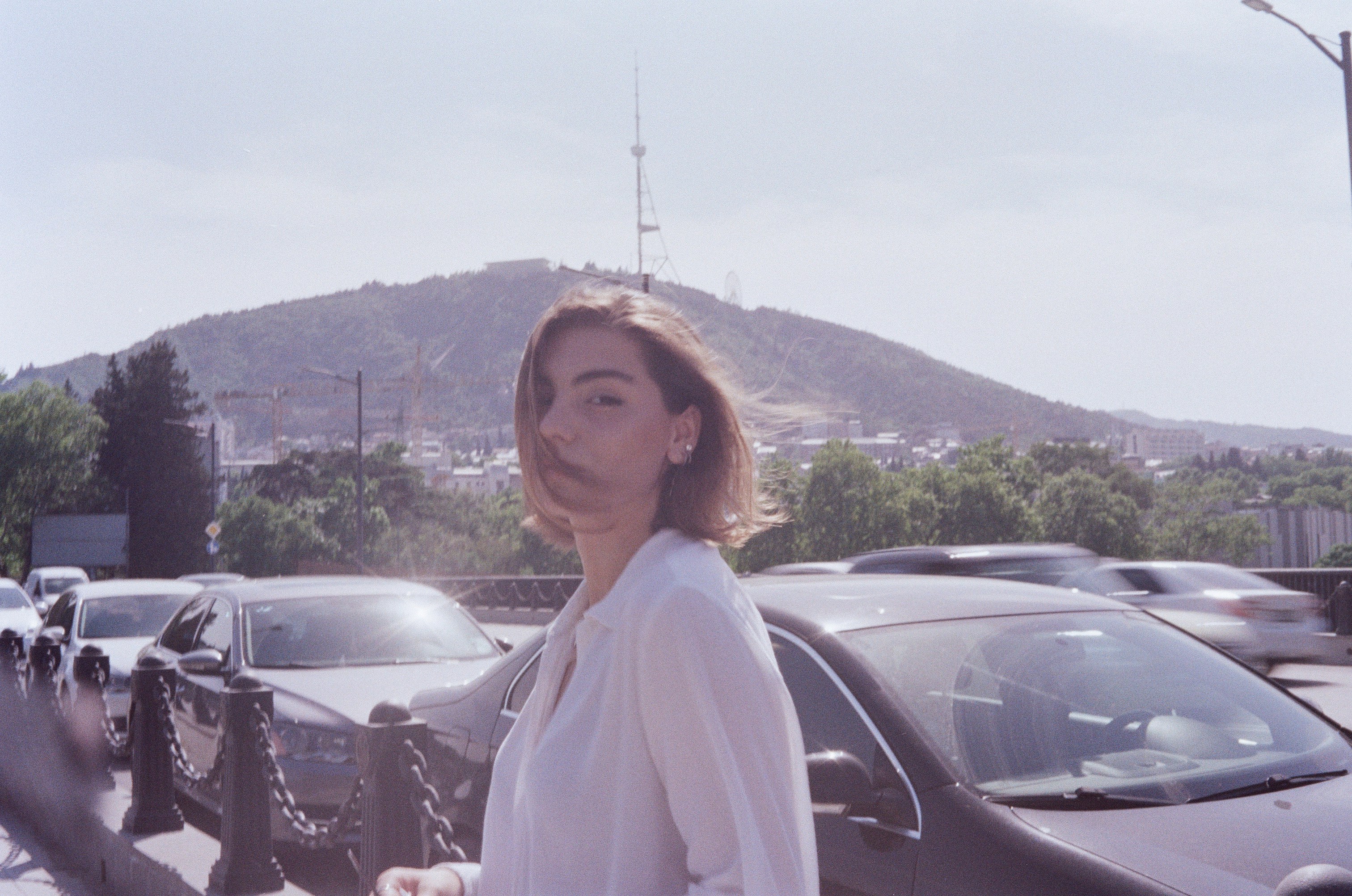 Woman in white long sleeve shirt standing beside black car during ...