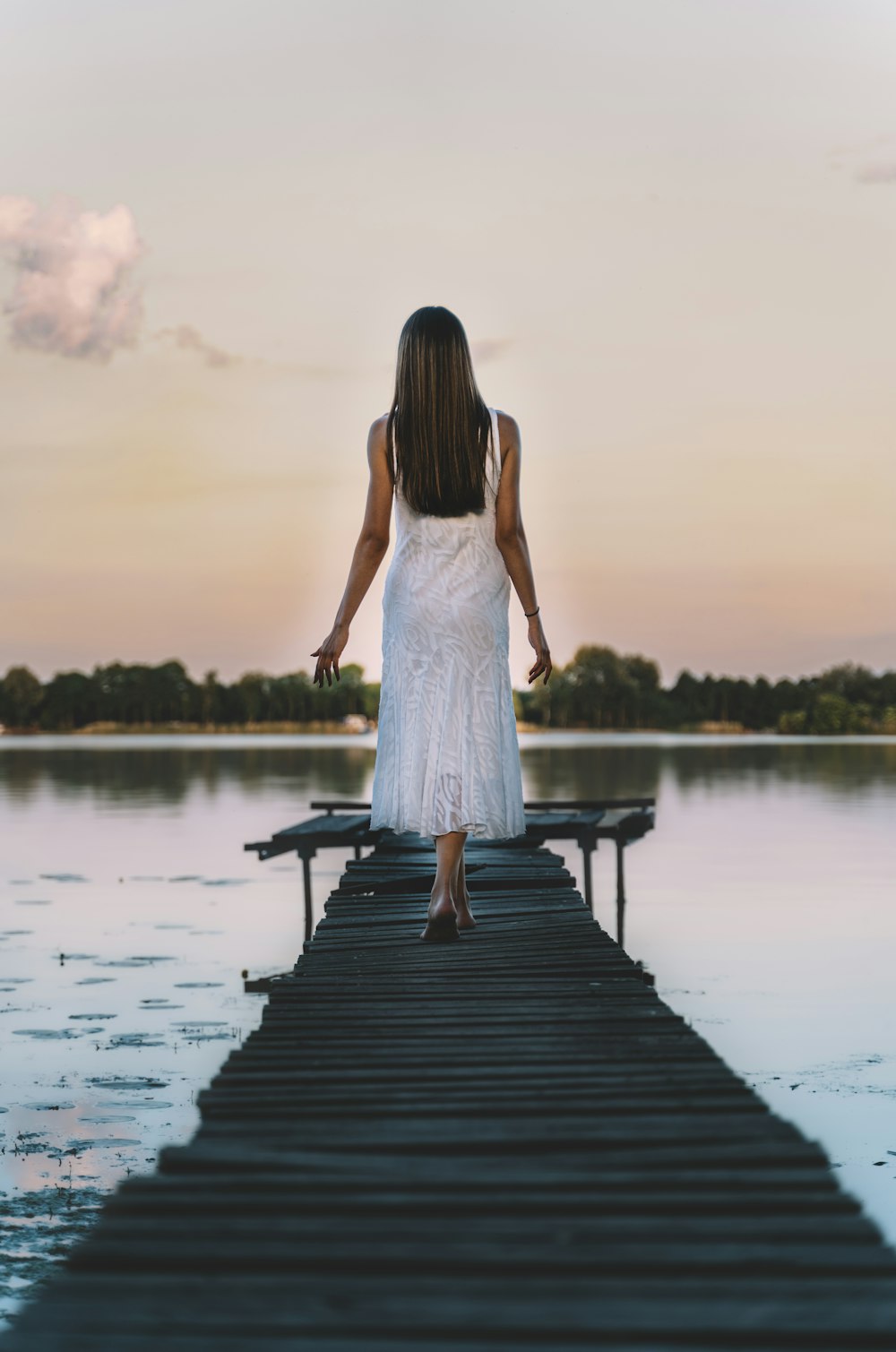 woman in white dress standing on dock during daytime