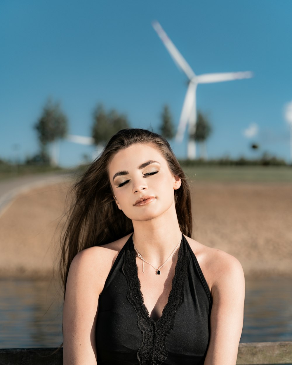 woman in black halter top standing near body of water during daytime