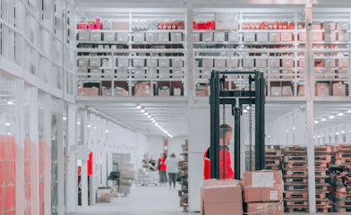 man in black pants and black jacket standing on black and red fork lift