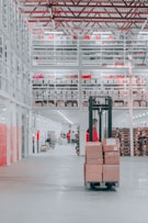 man in black pants and black jacket standing on black and red fork lift