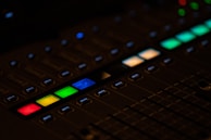 A close-up of a mixing console with colorful sound levels.