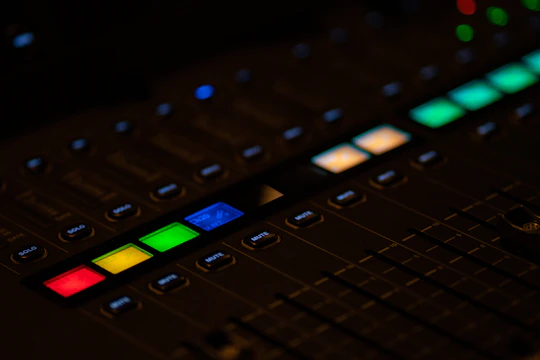 Close-up of mixing console with colorful knobs and sliders in a studio