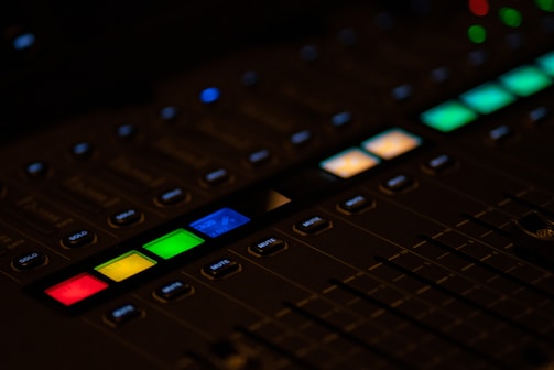 Close-up of mixing console with colorful sound wave displays.