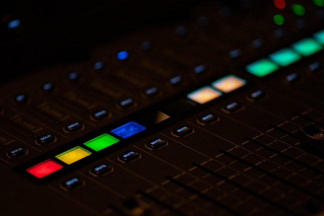 Mixing console with colorful illuminated knobs and sliders