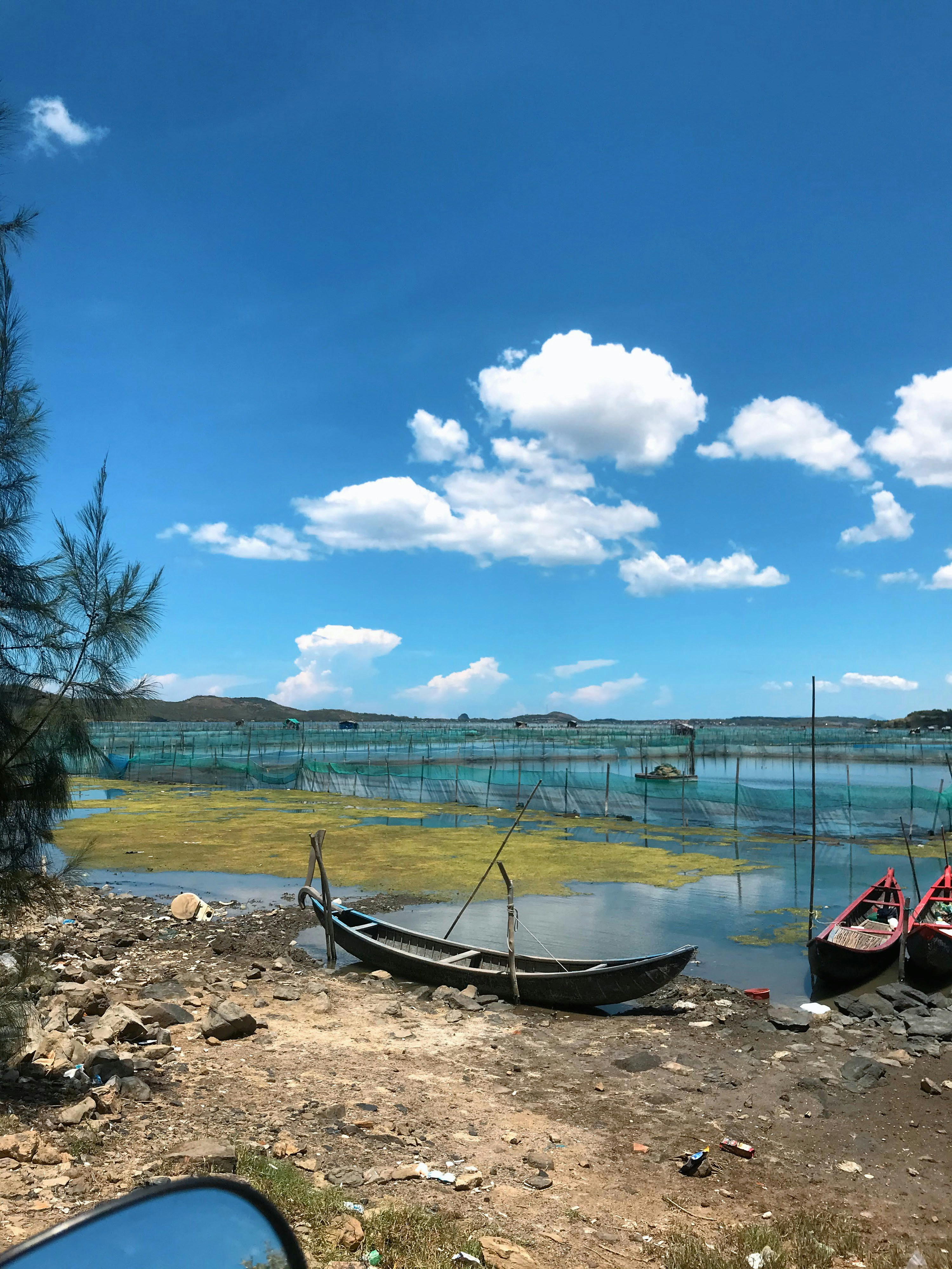 Schwarzes Boot auf braunem Sand in der Nähe von Gewässern tagsüber
