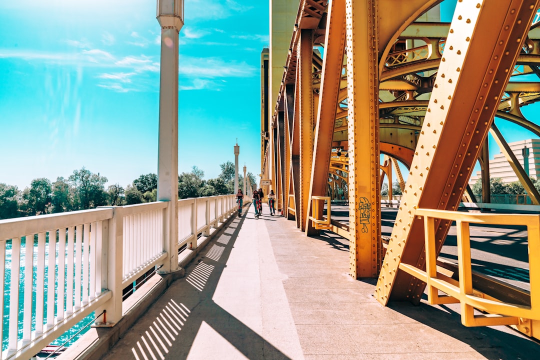 Riding scooters by the Sacramento River on the Tower Bridge overpass walkway.