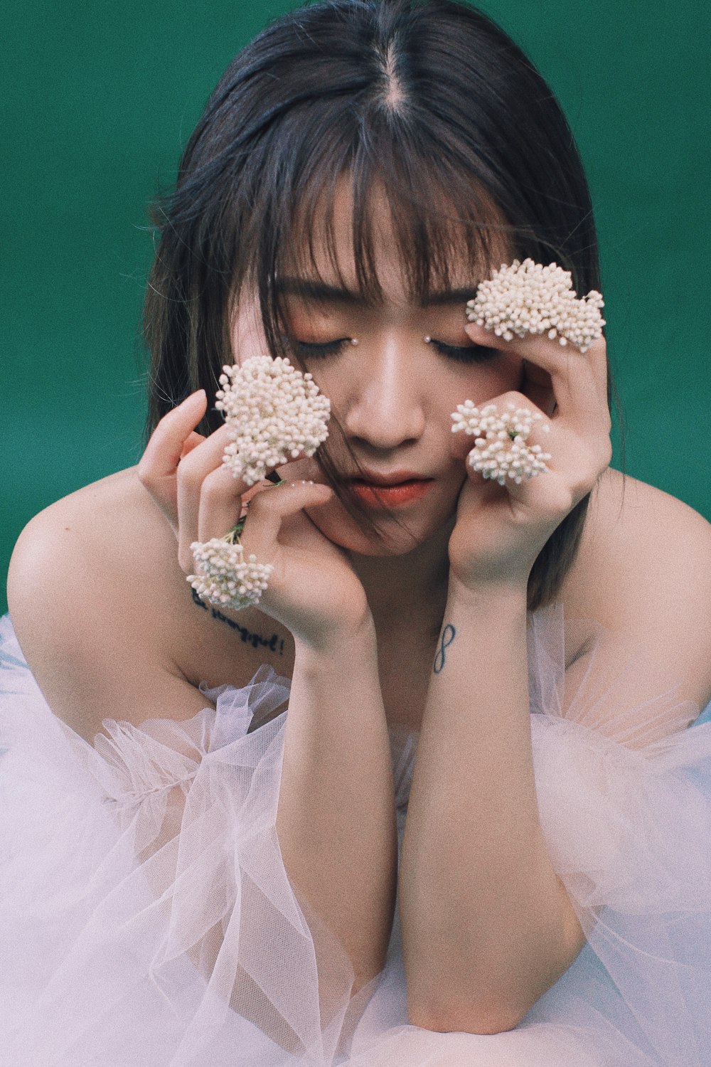 woman in white floral dress holding white flower