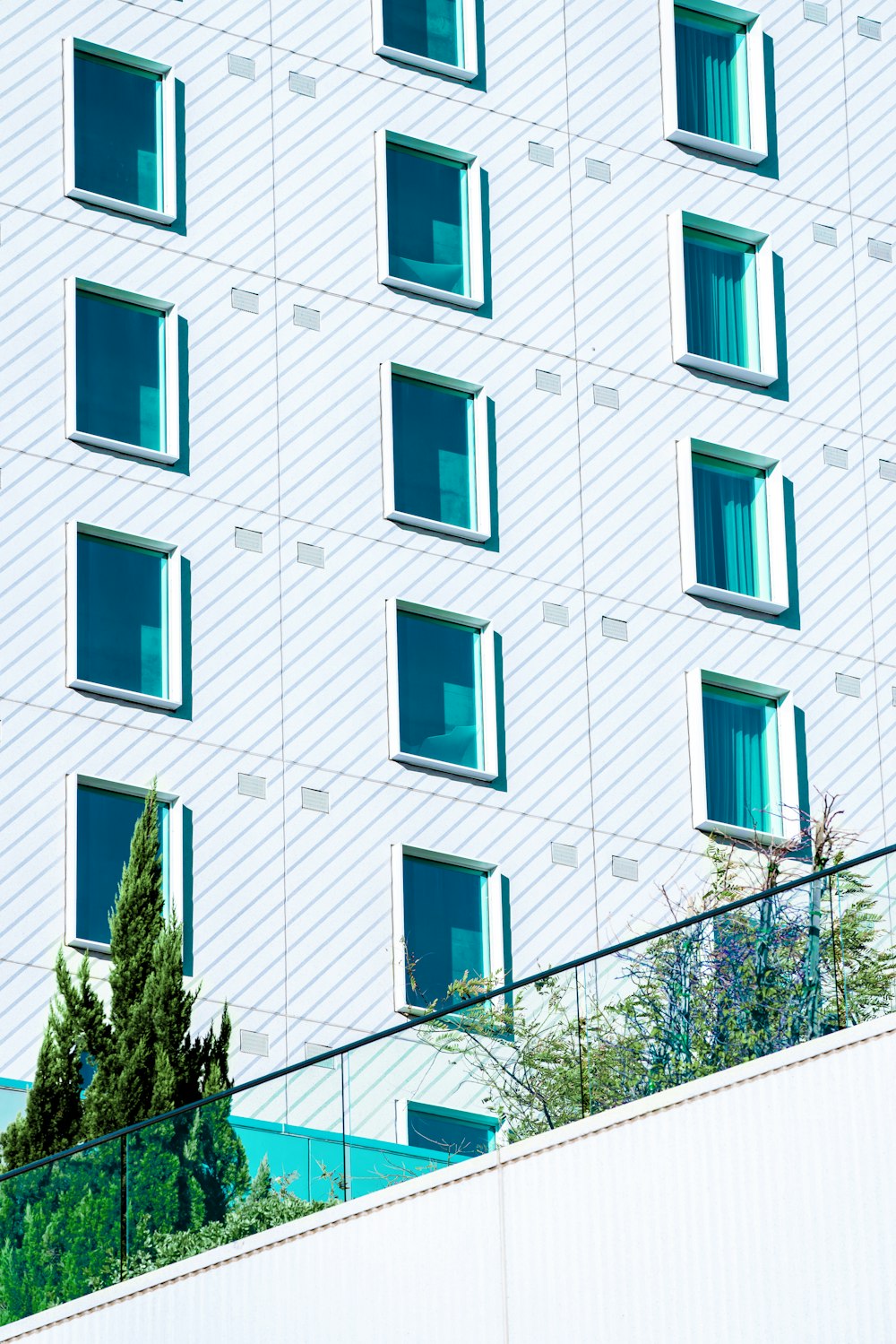 Bâtiment en béton blanc avec fenêtres bleues