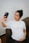 woman in white crew neck t-shirt holding black iphone 7 plus