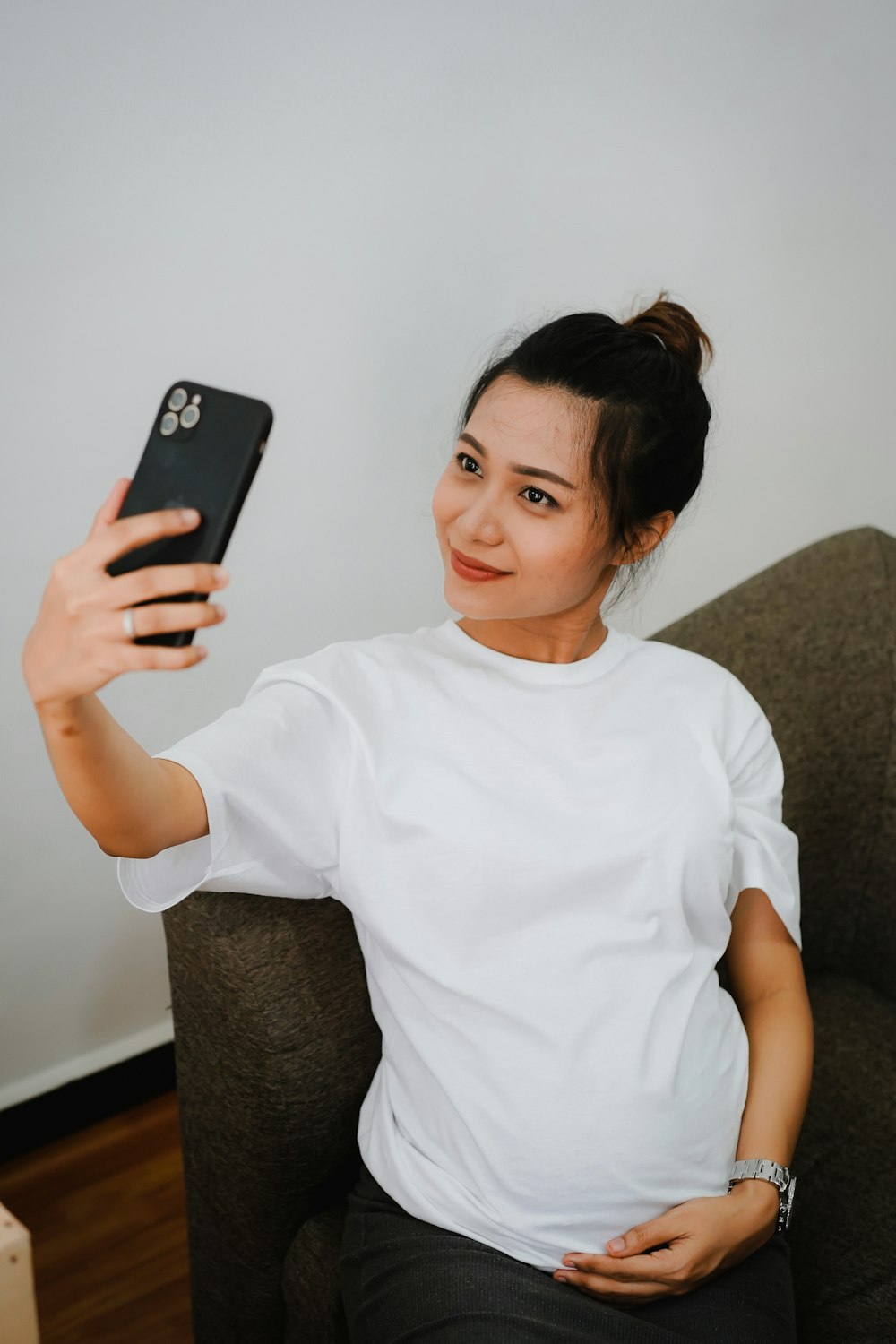 woman in white crew neck t-shirt holding black iphone 7 plus
