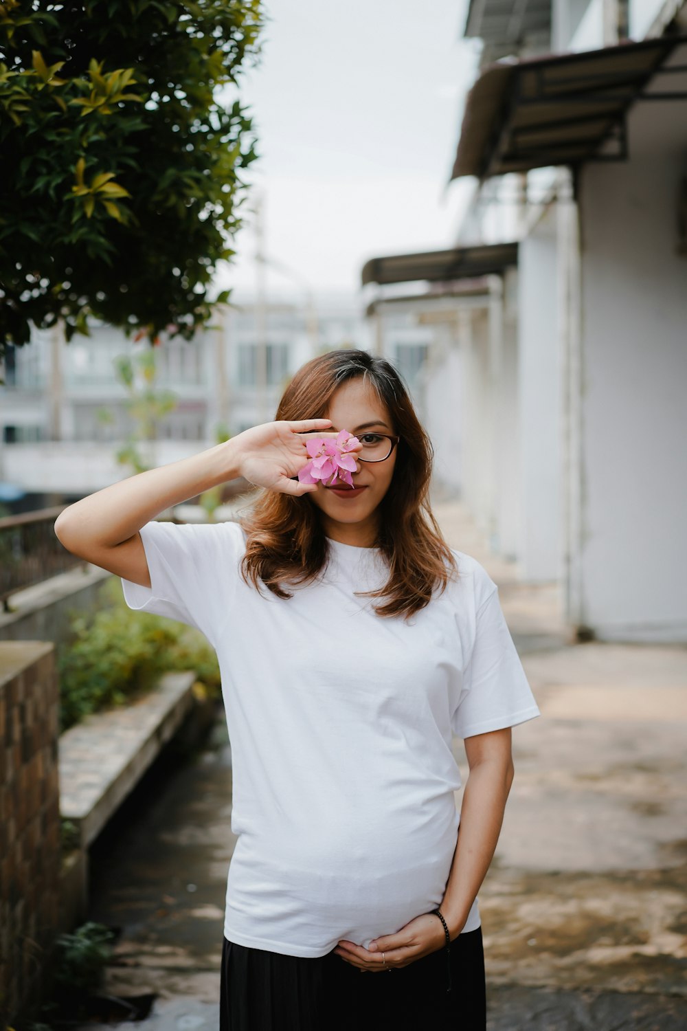 woman in white crew neck t-shirt with pink flower on her ear