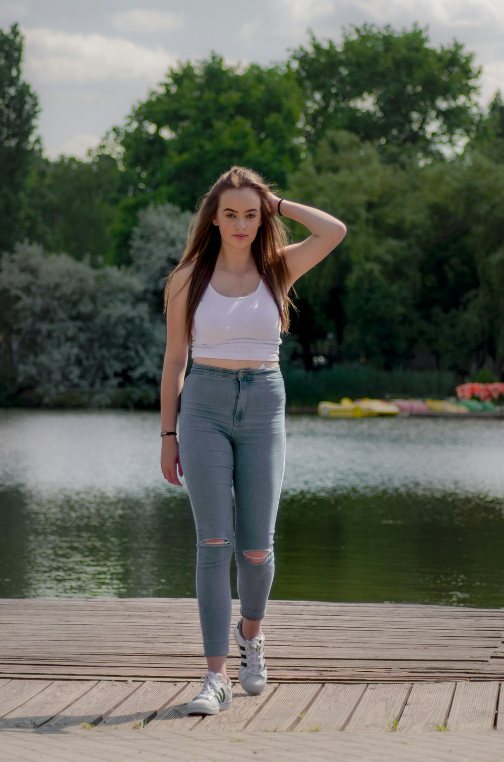 Woman in white tank top and blue denim jeans standing on wooden dock during  daytime photo – Free Human Image on Unsplash