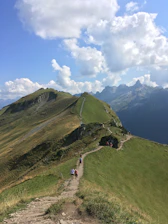 A traveler enjoying a scenic mountain trail surrounded by lush greenery.